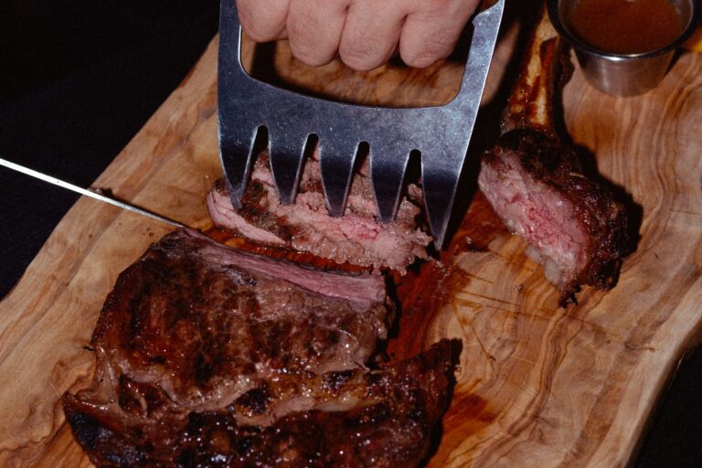 Bone-in rib eye carved on an olive-wood board at Moo Casa